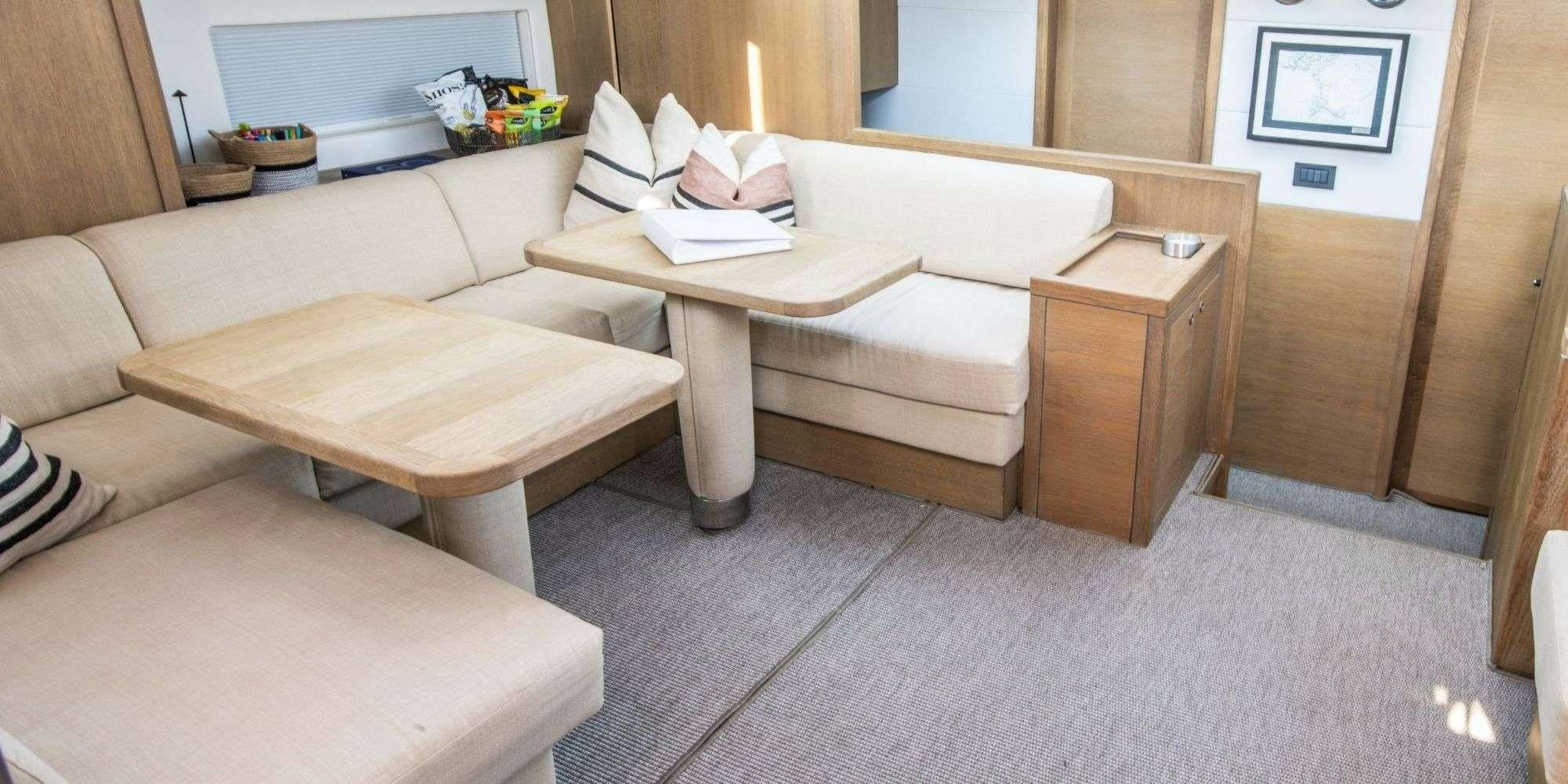 a living room with a couch and coffee table aboard CHAMPAGNE HIPPY Yacht for Charter