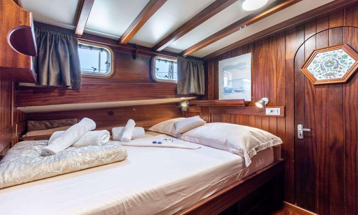 a room with a bed and a wood cabinet aboard ANGELICA Yacht for Charter