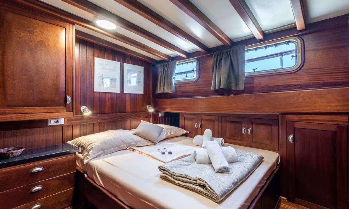 a room with a bed and cabinets aboard ANGELICA Yacht for Charter