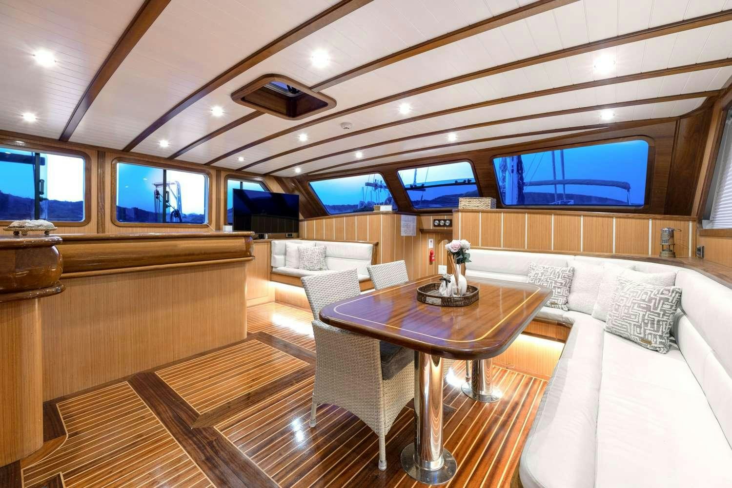 a room with a table and couches aboard GOZDEM THE ONE Yacht for Charter