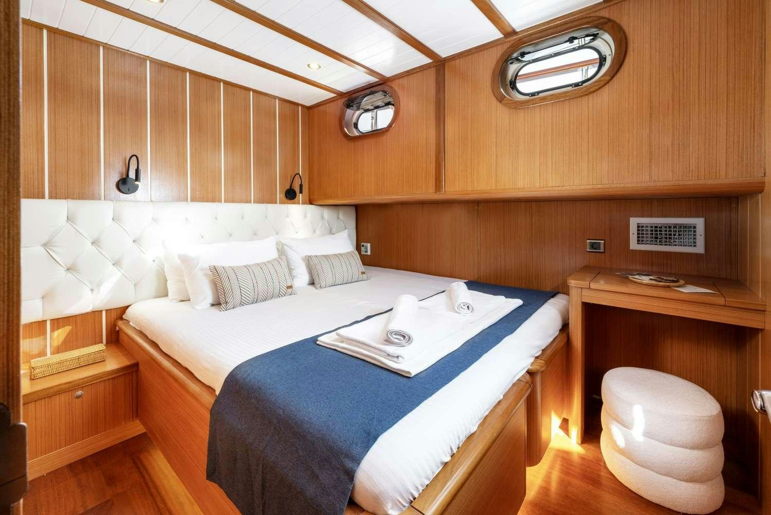 a room with a bed and a desk aboard GOZDEM THE ONE Yacht for Charter