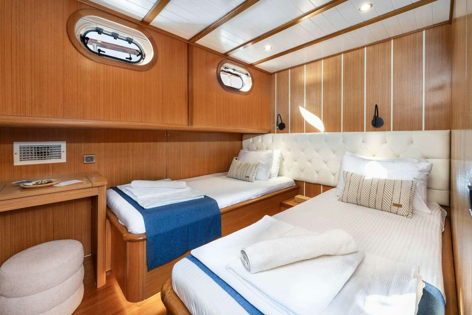 a room with beds and a table aboard GOZDEM THE ONE Yacht for Charter