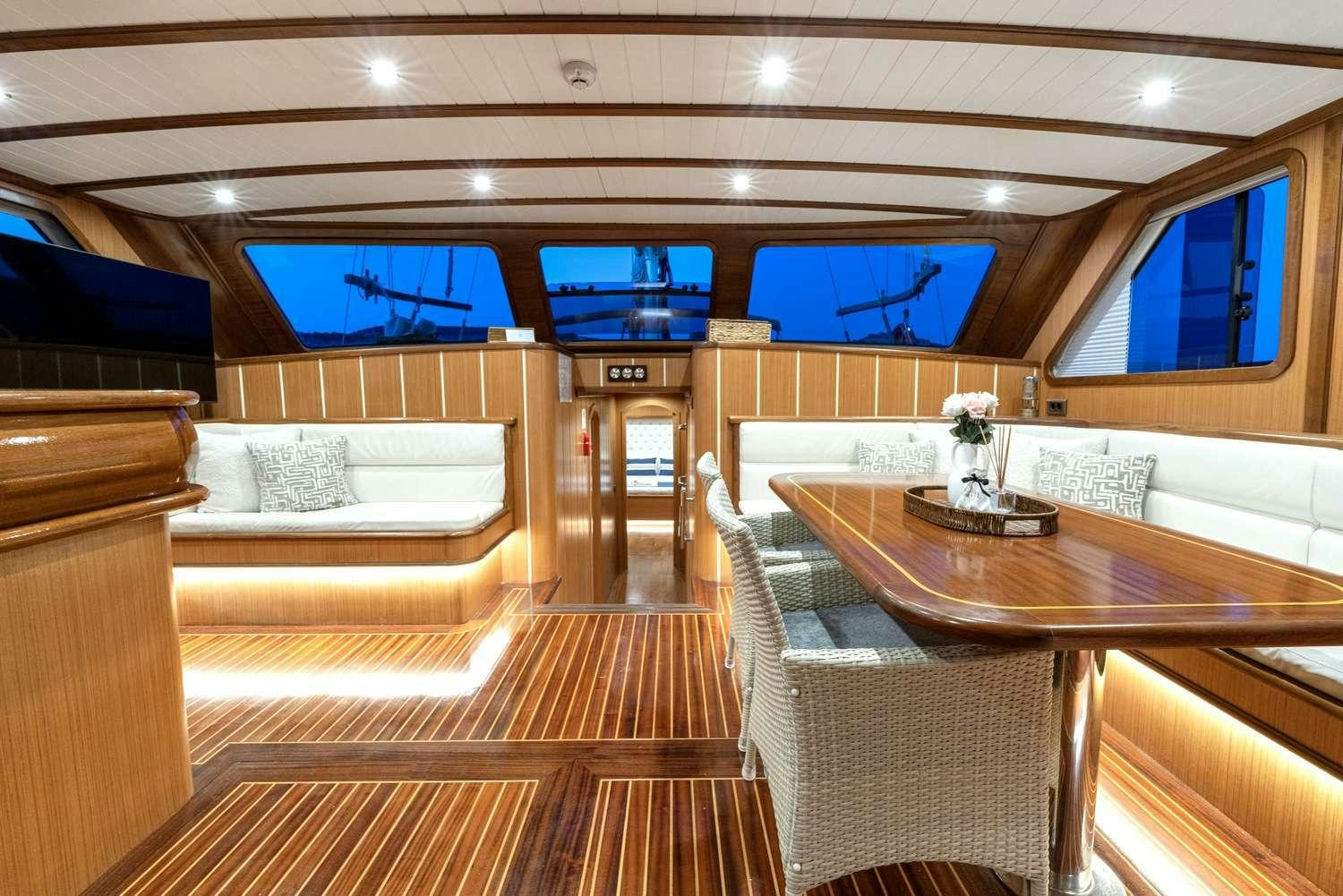a room with a table and couches aboard GOZDEM THE ONE Yacht for Charter