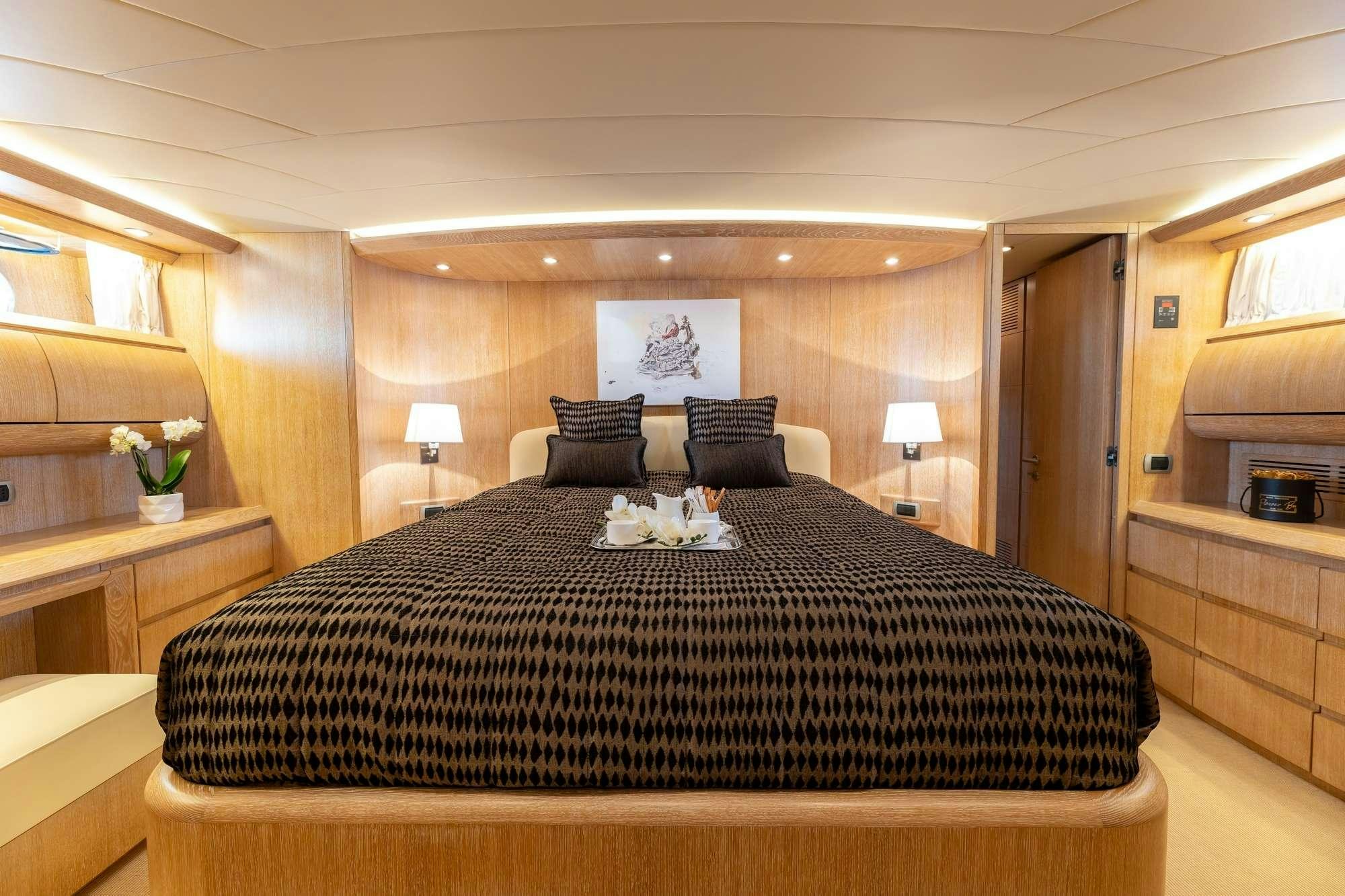 a bed with a black comforter aboard COOKIE Yacht for Charter