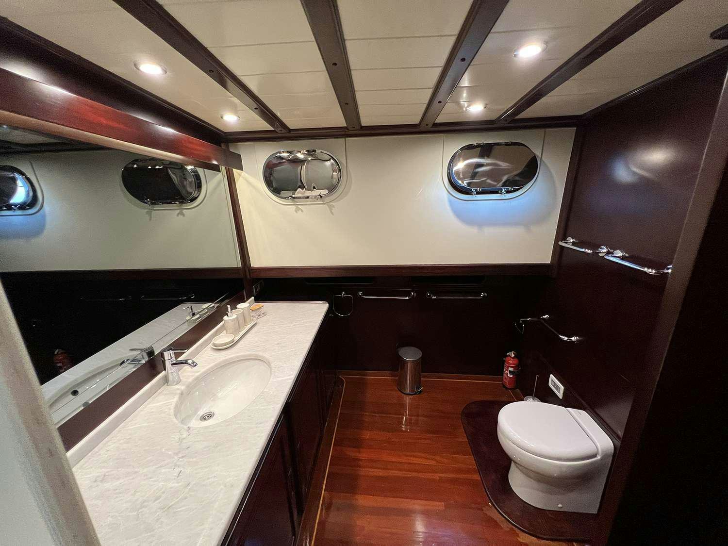 a bathroom with a large oval mirror aboard ALWAYS SMILE Yacht for Charter