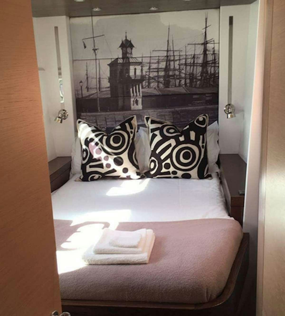 a bed with pillows and a pillow aboard HQ2 Yacht for Charter