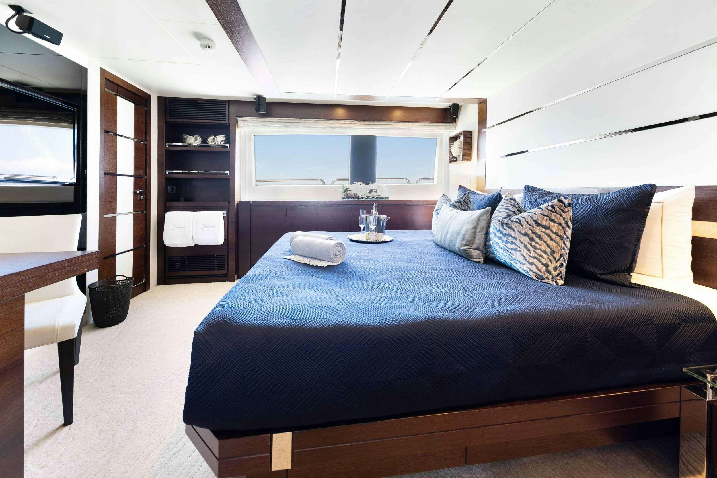 a bed with a blue comforter aboard CAMY ED Yacht for Charter