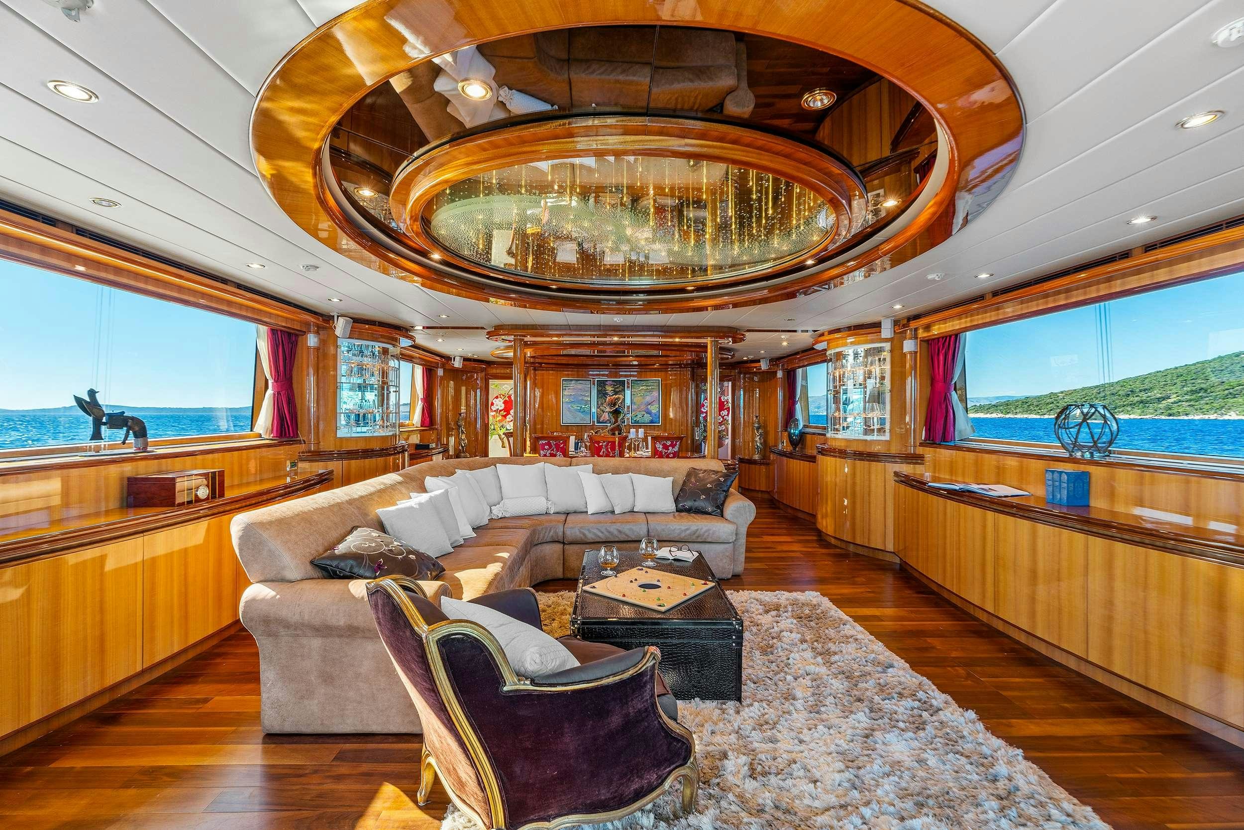 a large living room with a chandelier aboard CONTE STEFANI Yacht for Charter