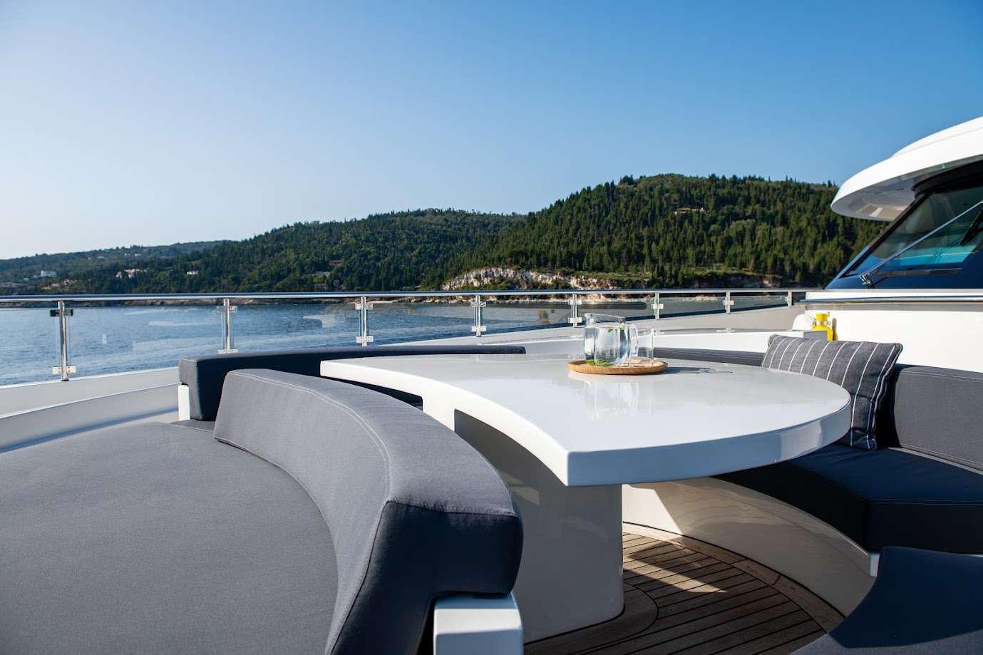 a table on a deck overlooking a body of water aboard ZIA Yacht for Charter
