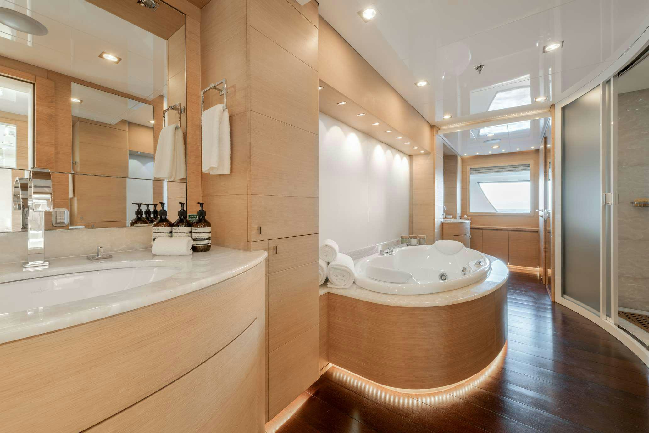a bathroom with a tub sink and a wood floor aboard ZIA Yacht for Charter