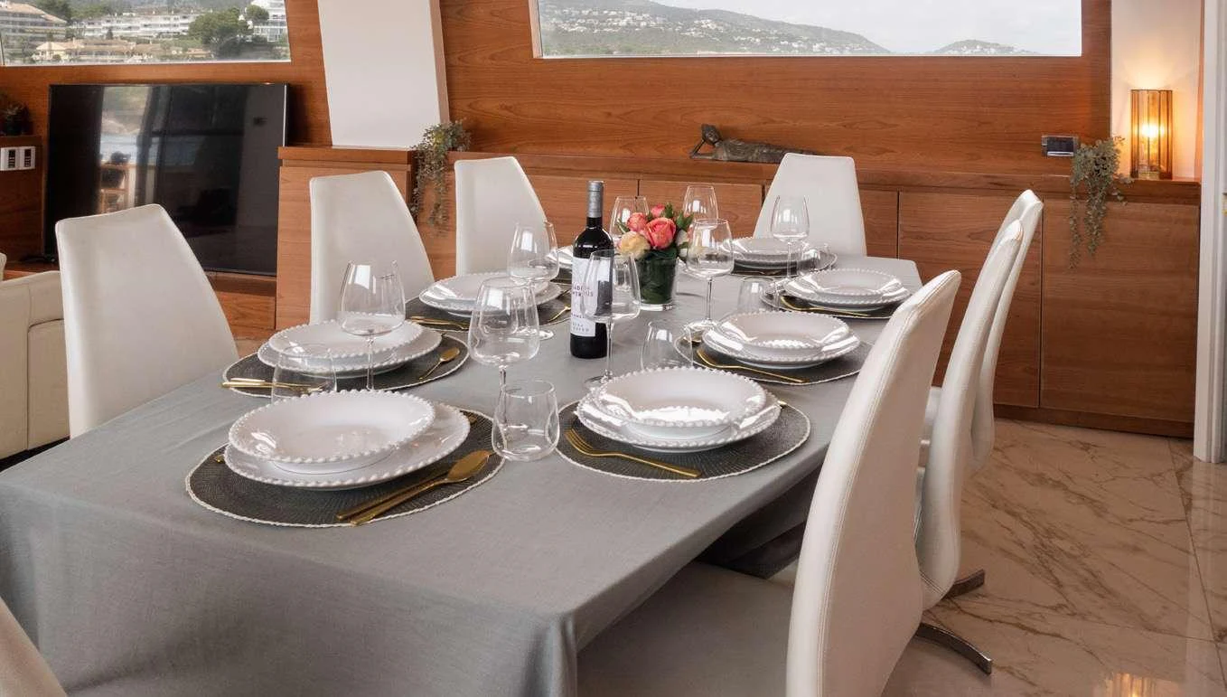 a table set with plates and glasses aboard BLUE GOLD Yacht for Charter