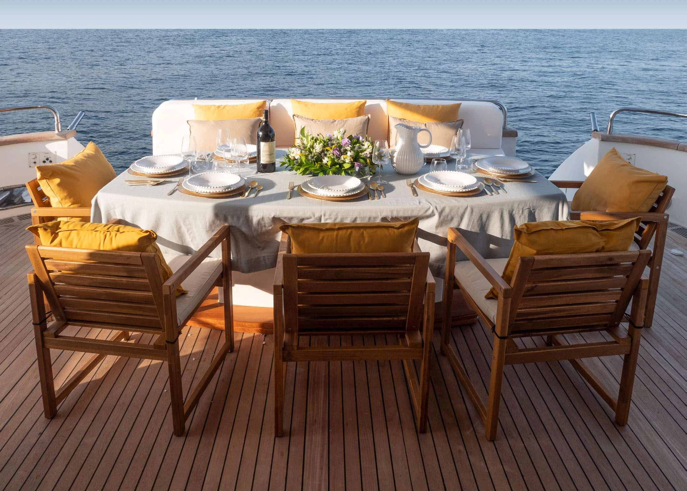 a table set with chairs and a view of the ocean aboard BLUE GOLD Yacht for Charter