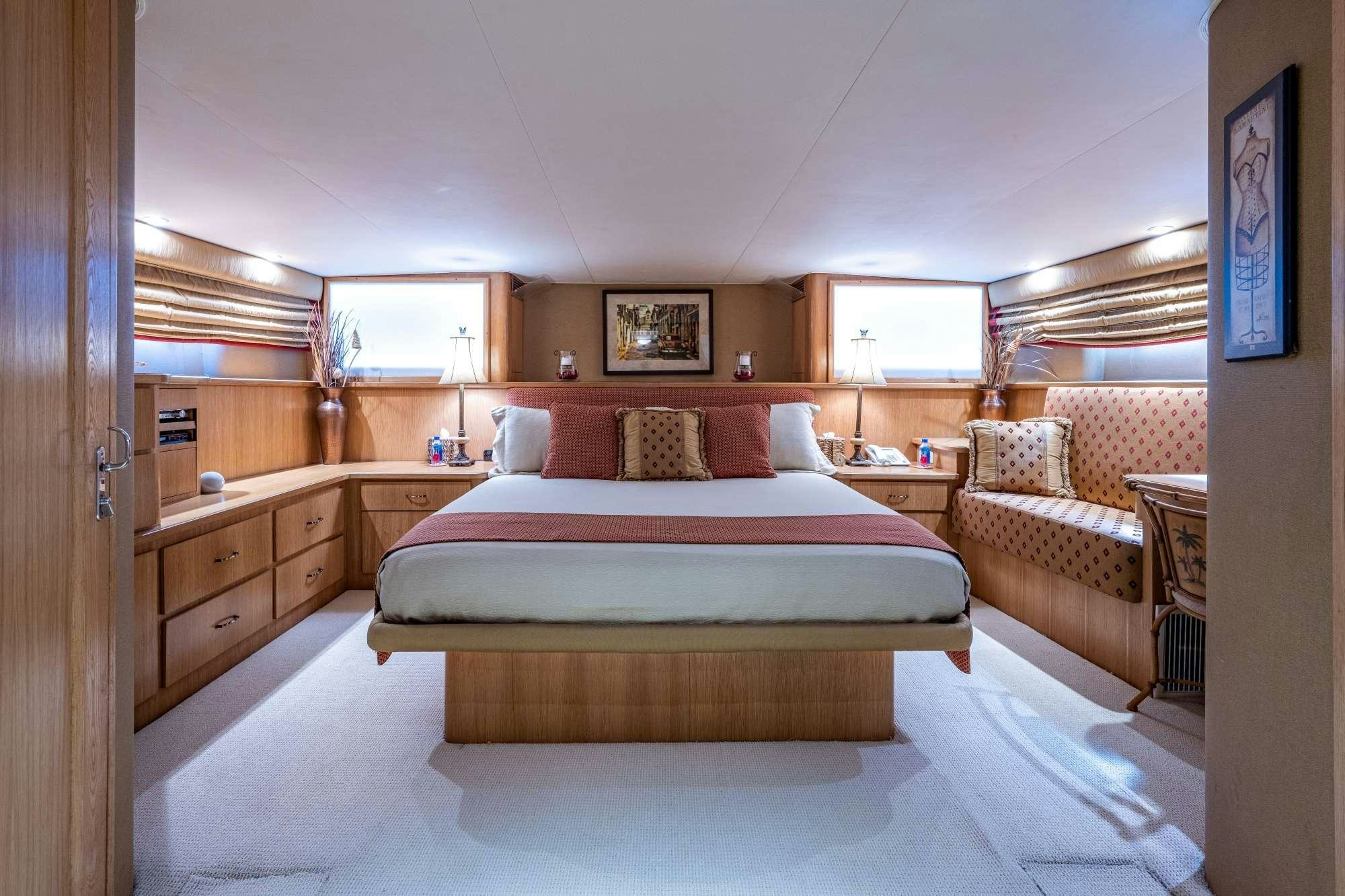 a bedroom with a bed and a couch aboard BANDIT Yacht for Charter