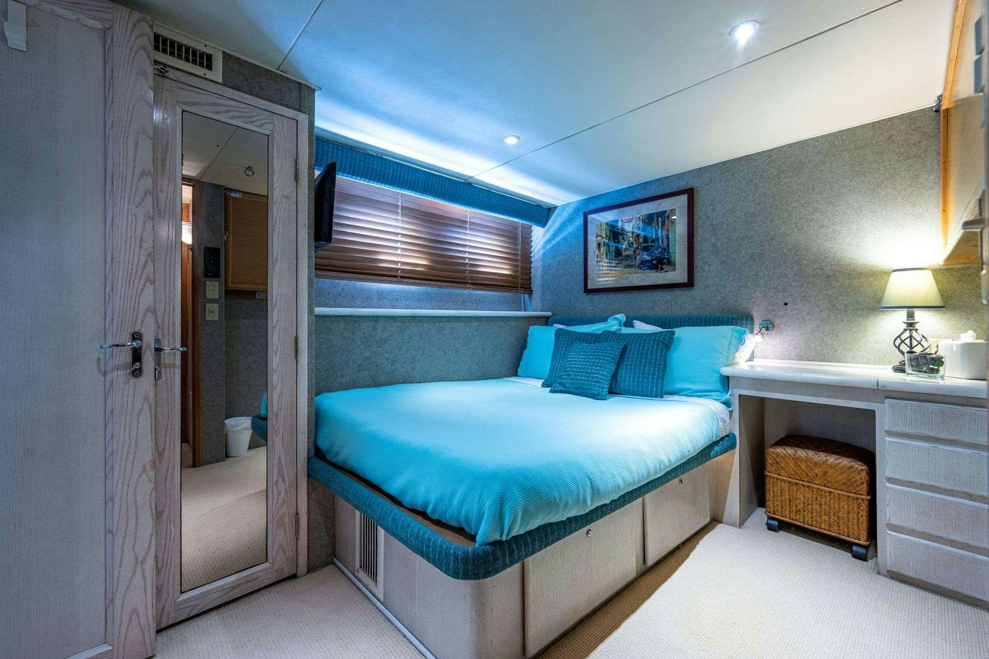 a bedroom with a bed and a desk aboard BANDIT Yacht for Charter
