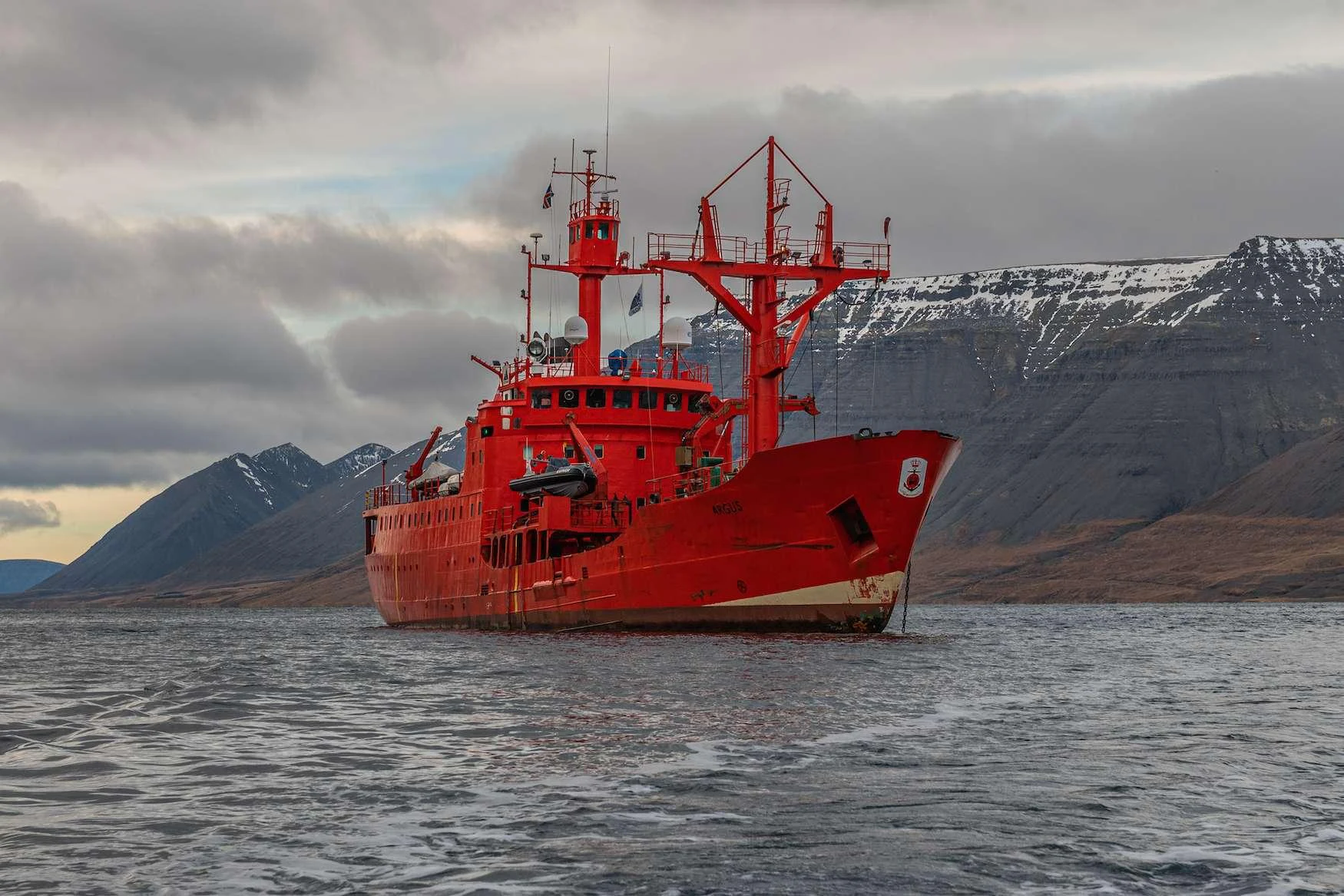 a red boat in the water aboard ARGUS Yacht for Charter