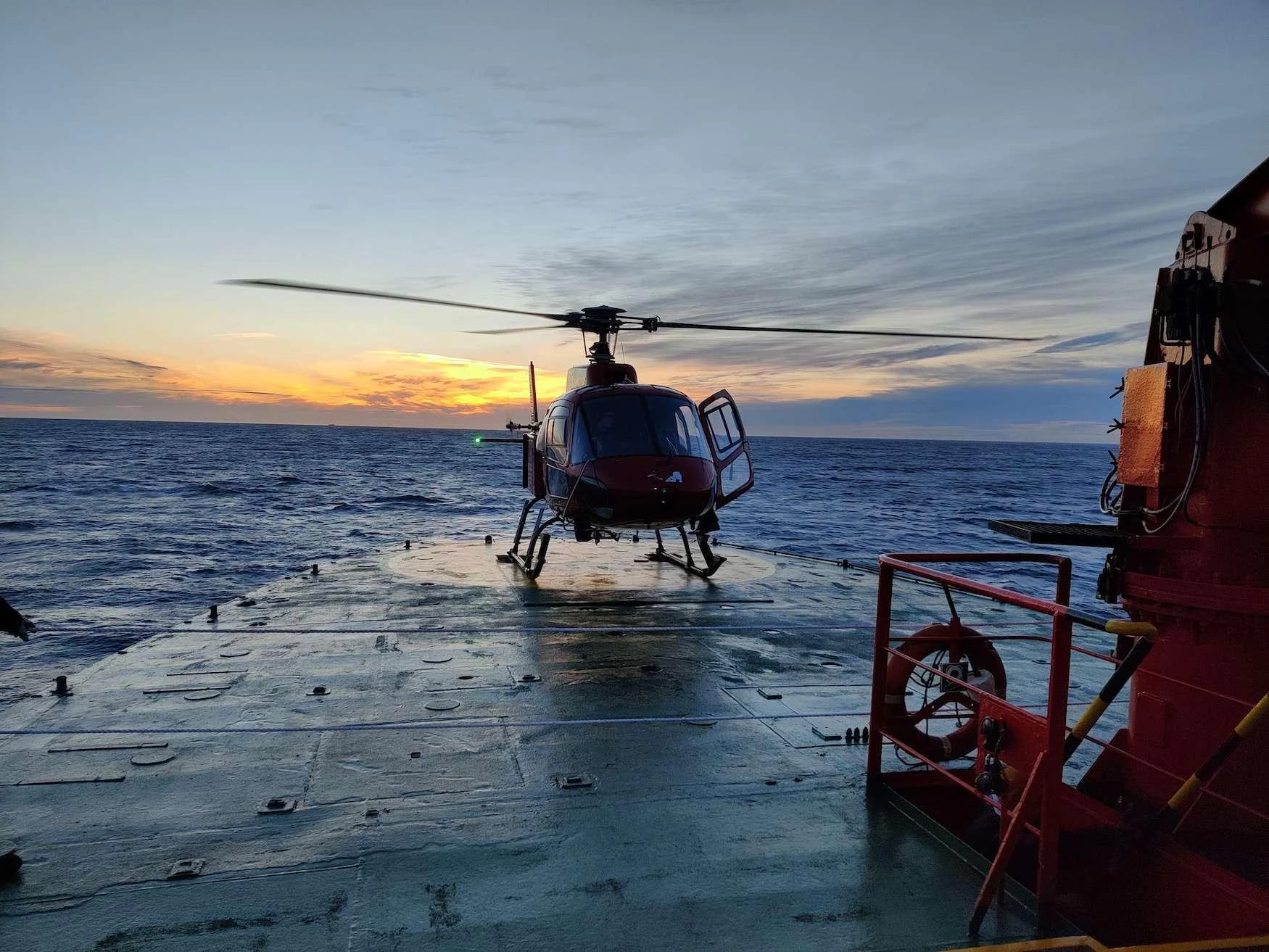 a helicopter landing on a dock aboard ARGUS Yacht for Charter