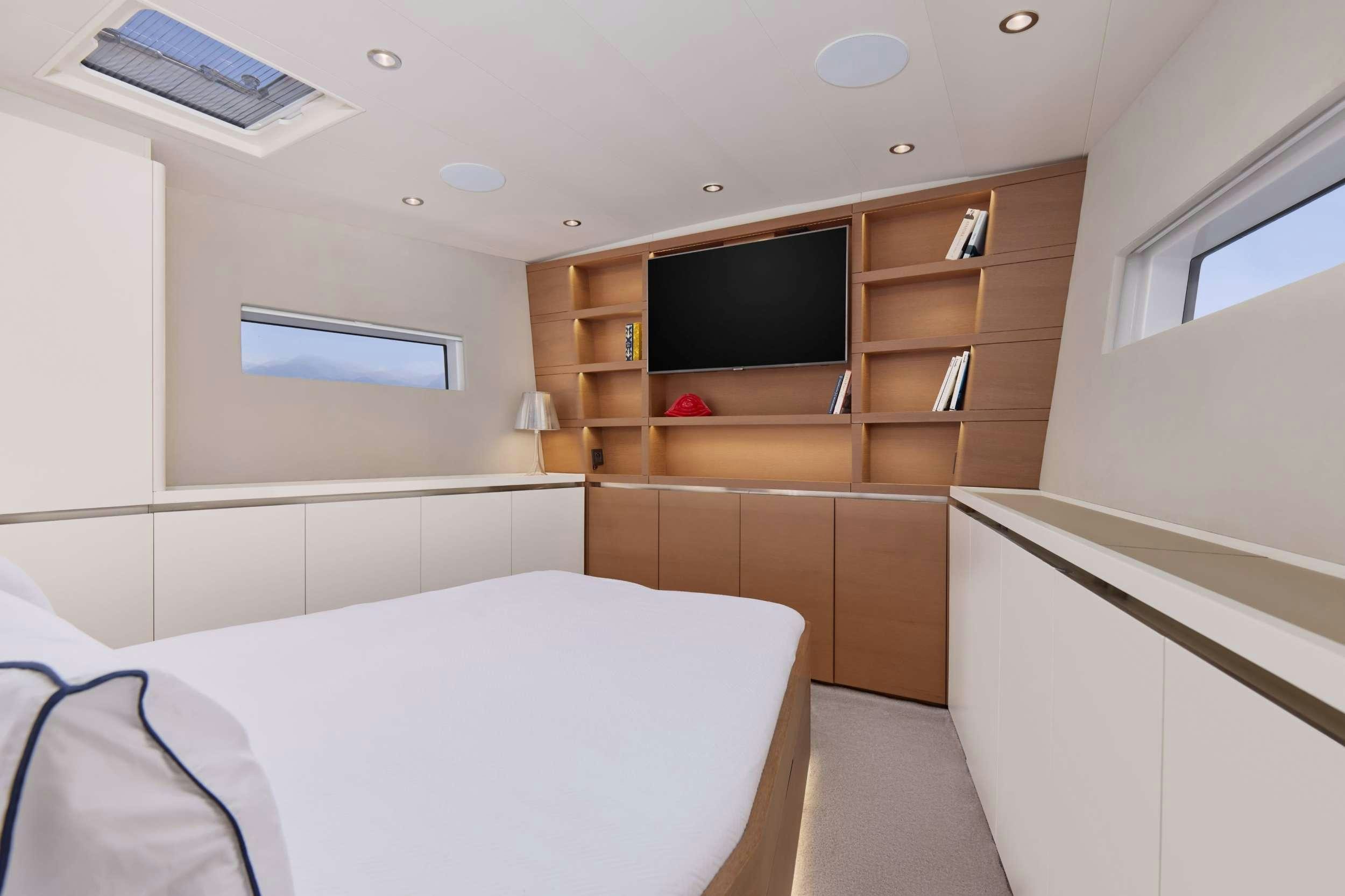 a room with a bed and a television aboard GRATEFUL Yacht for Charter