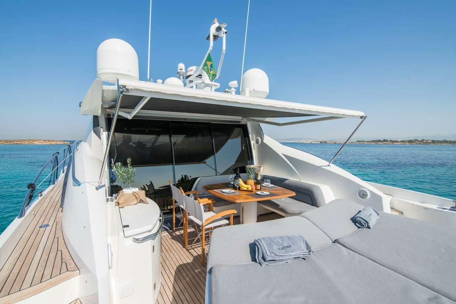 a boat with a table and chairs on the deck aboard ELENTARI Yacht for Charter