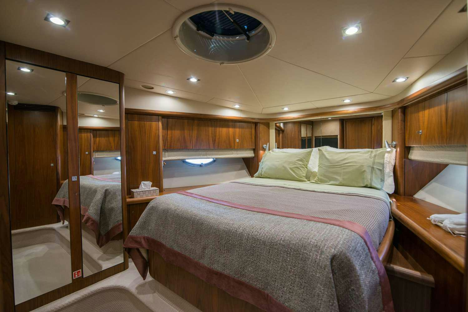 a bedroom with a bed and a mirror aboard ELENTARI Yacht for Charter