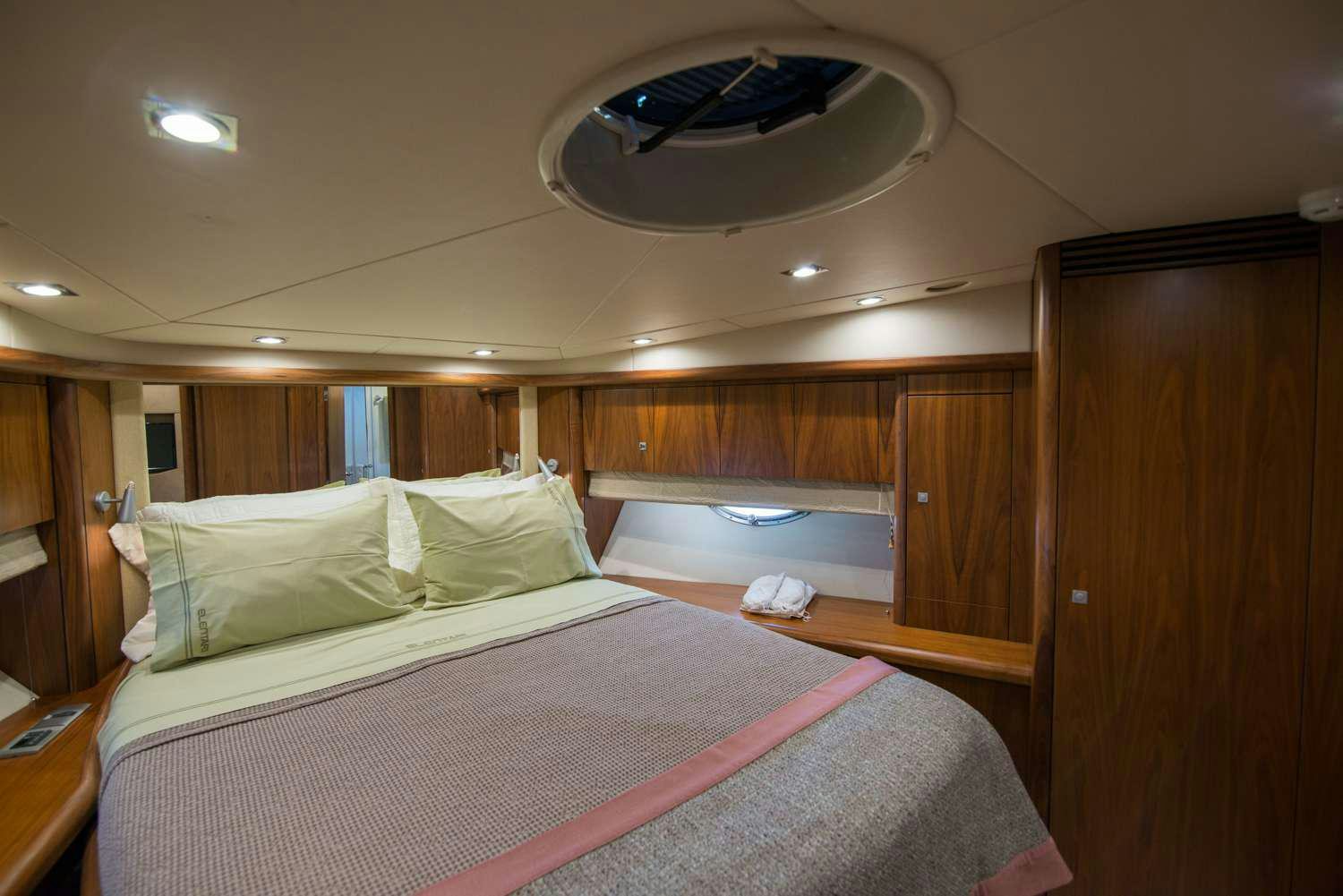 a room with a bed and a desk aboard ELENTARI Yacht for Charter