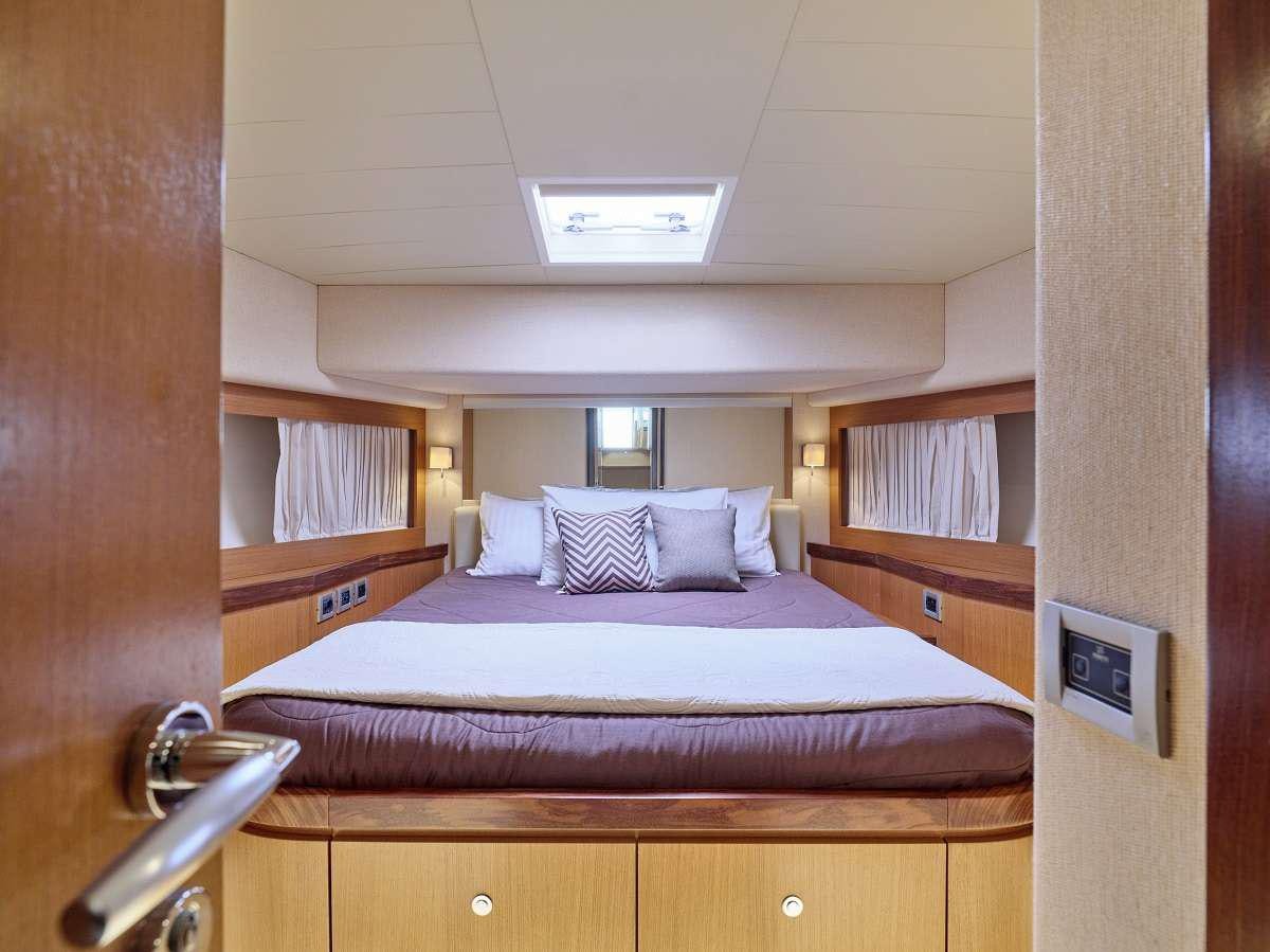 a bed with a purple sheet aboard FLOW Yacht for Charter