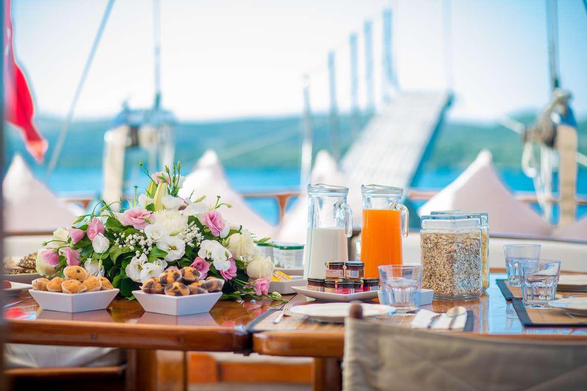 a table with food and drinks aboard P Yacht for Charter
