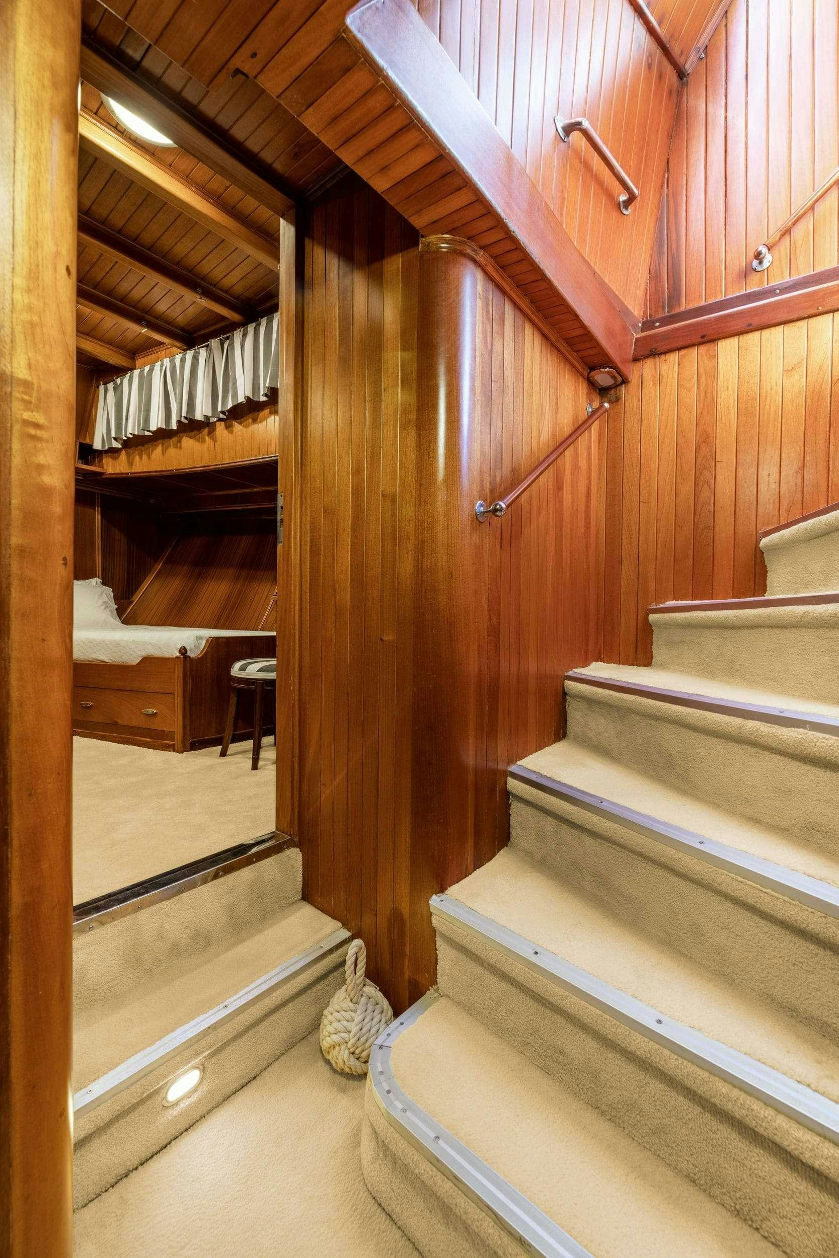 a wooden staircase inside a house aboard LITHI Yacht for Charter