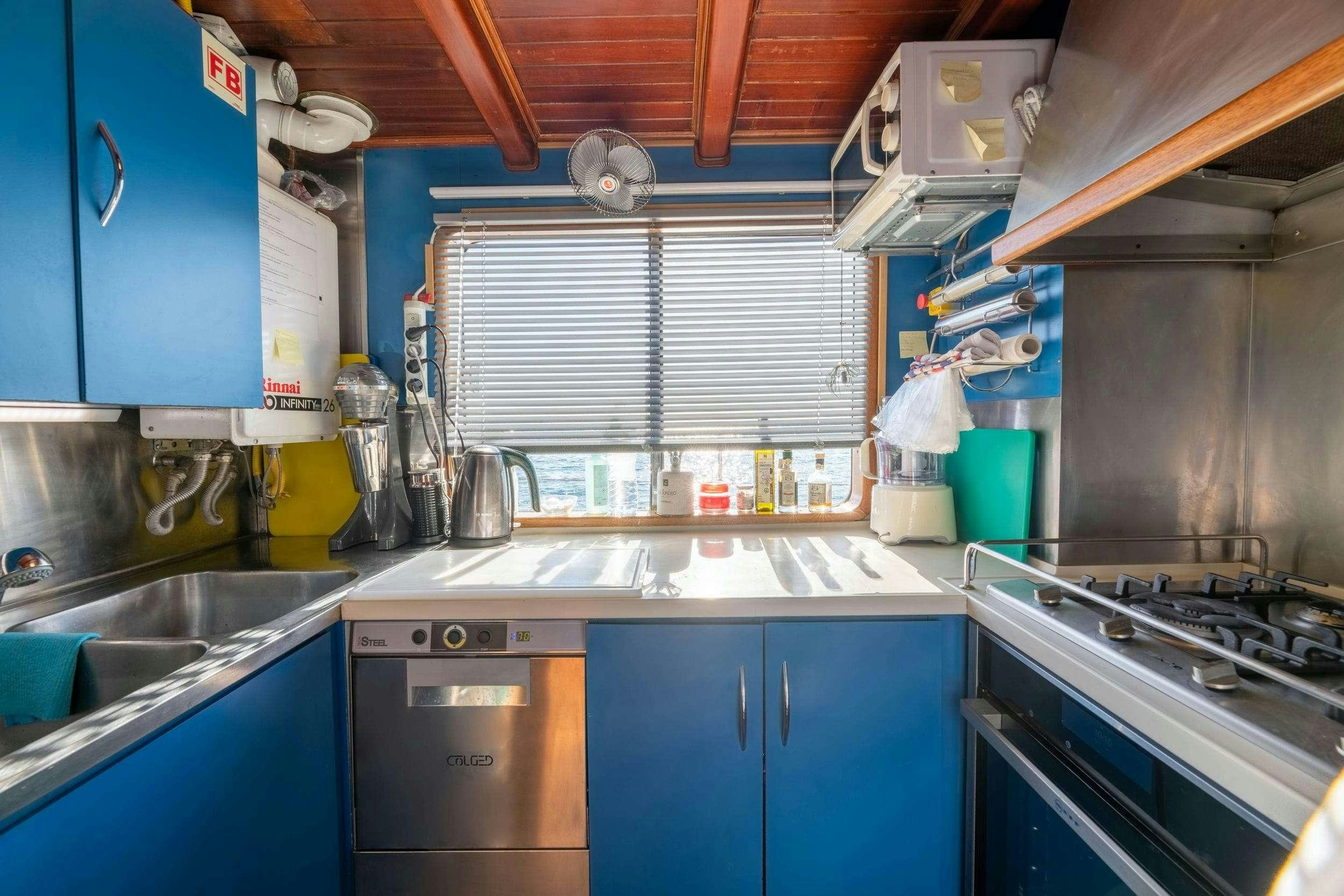 a kitchen with blue cabinets aboard LITHI Yacht for Charter