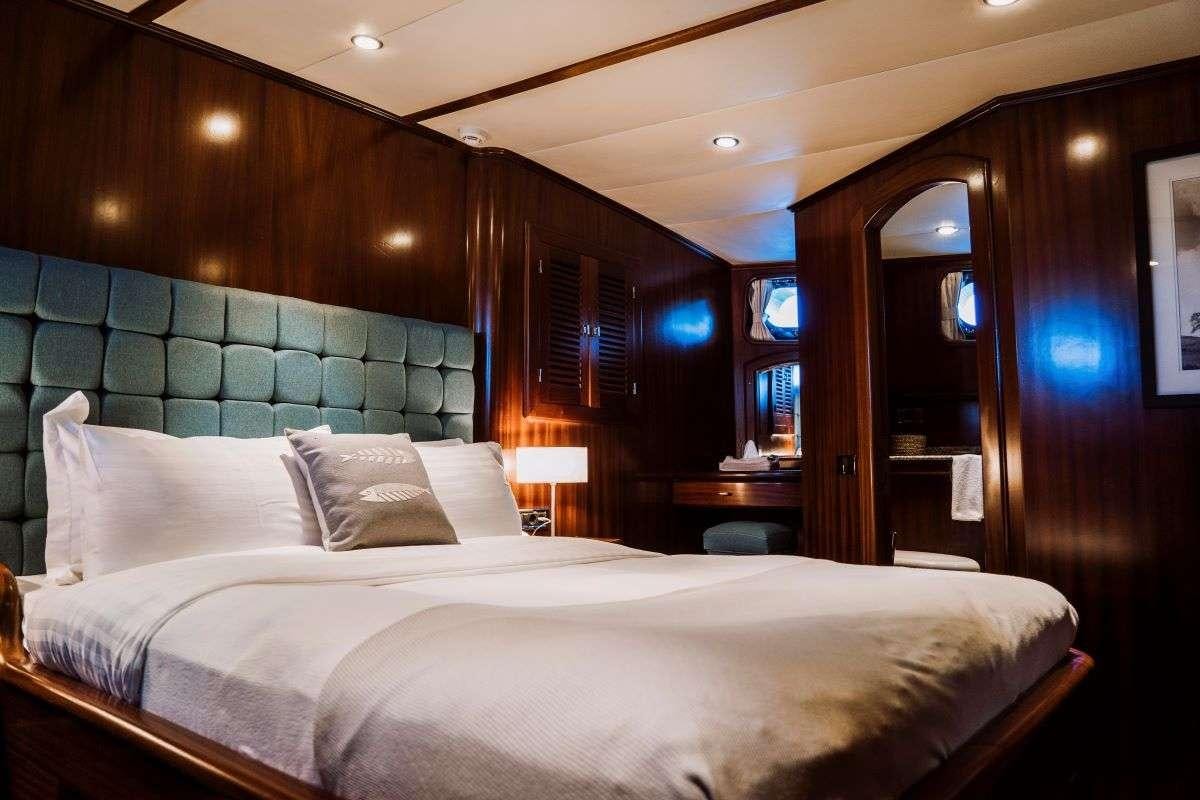 a bed with a white sheet aboard CAPRICORN ONE Yacht for Charter