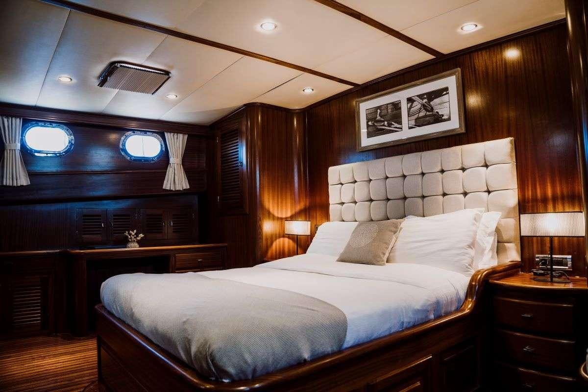 a bedroom with a bed and a desk aboard CAPRICORN ONE Yacht for Charter