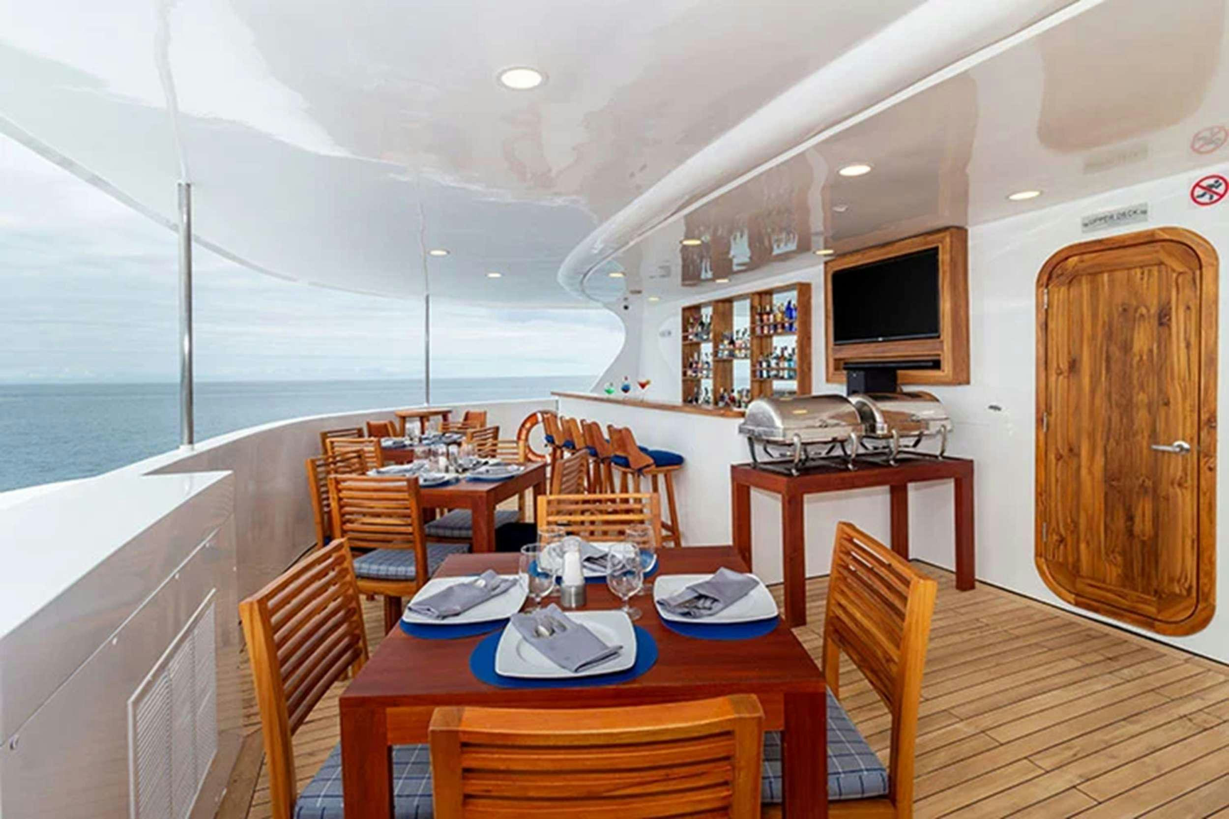a dining room with a table and chairs aboard GALAPAGOS HORIZON Yacht for Charter