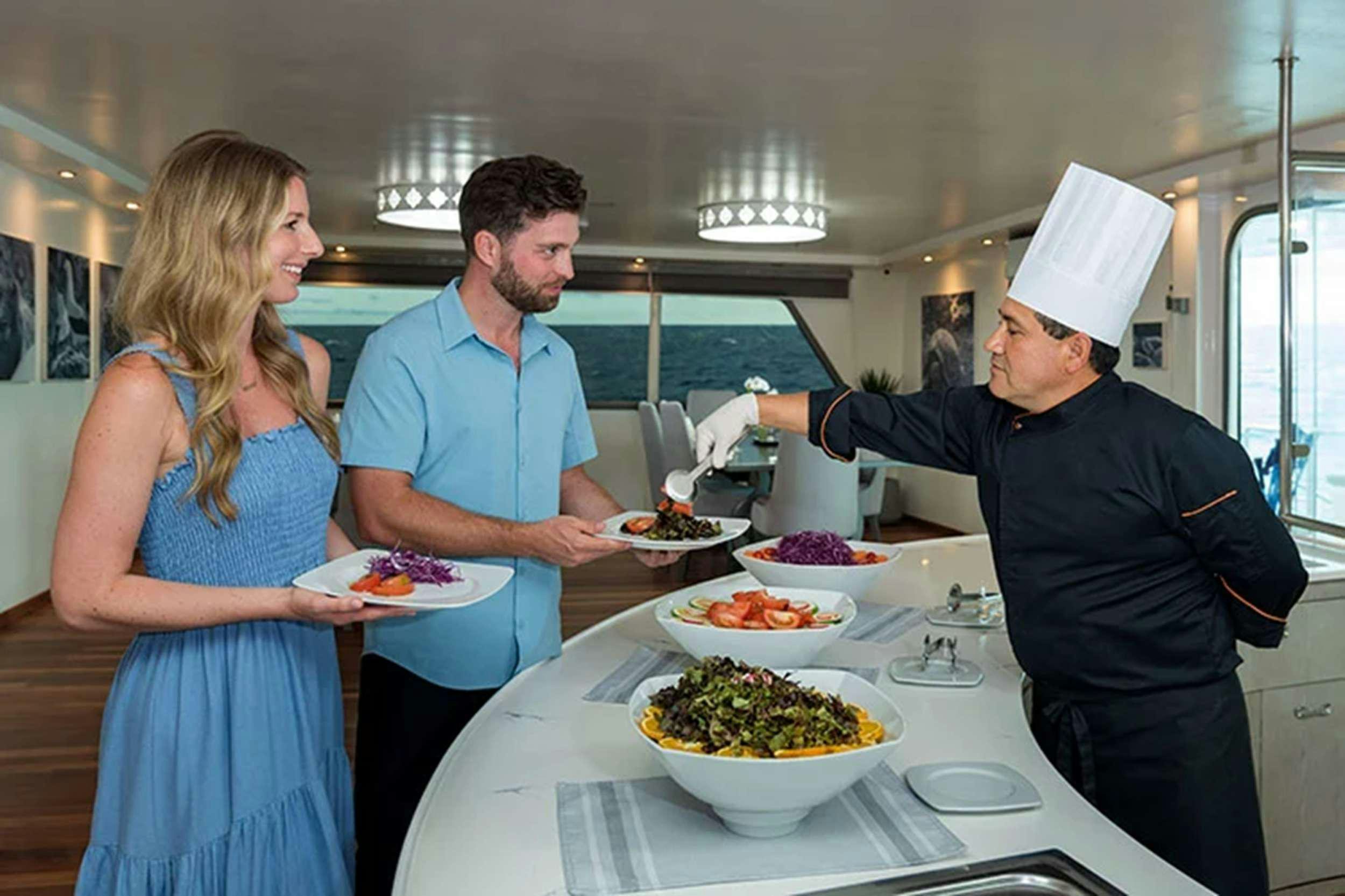a group of people in a kitchen aboard GALAPAGOS HORIZON Yacht for Charter
