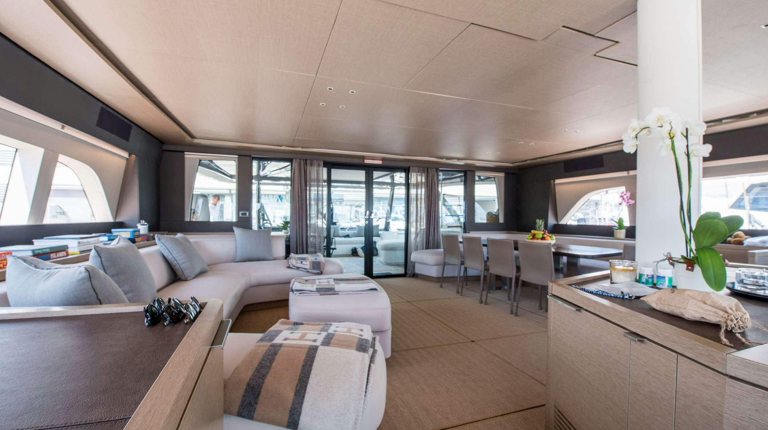 a living room with a large window aboard CAT TUA Yacht for Charter