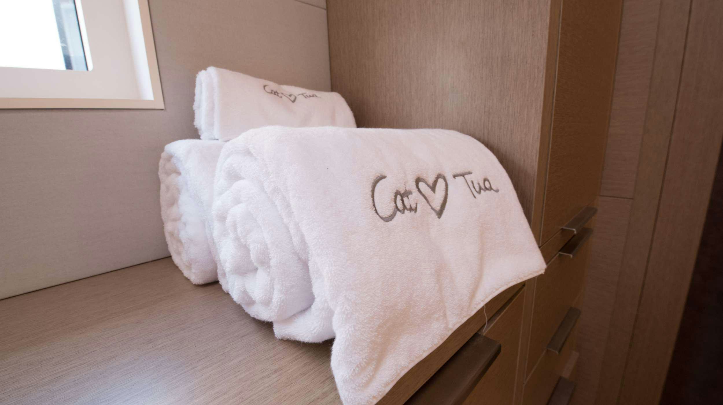 a white pillow on a wooden surface aboard CAT TUA Yacht for Charter