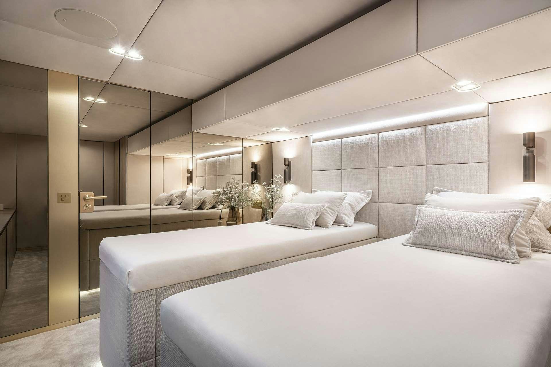 a room with white bedding aboard MANTA Yacht for Charter