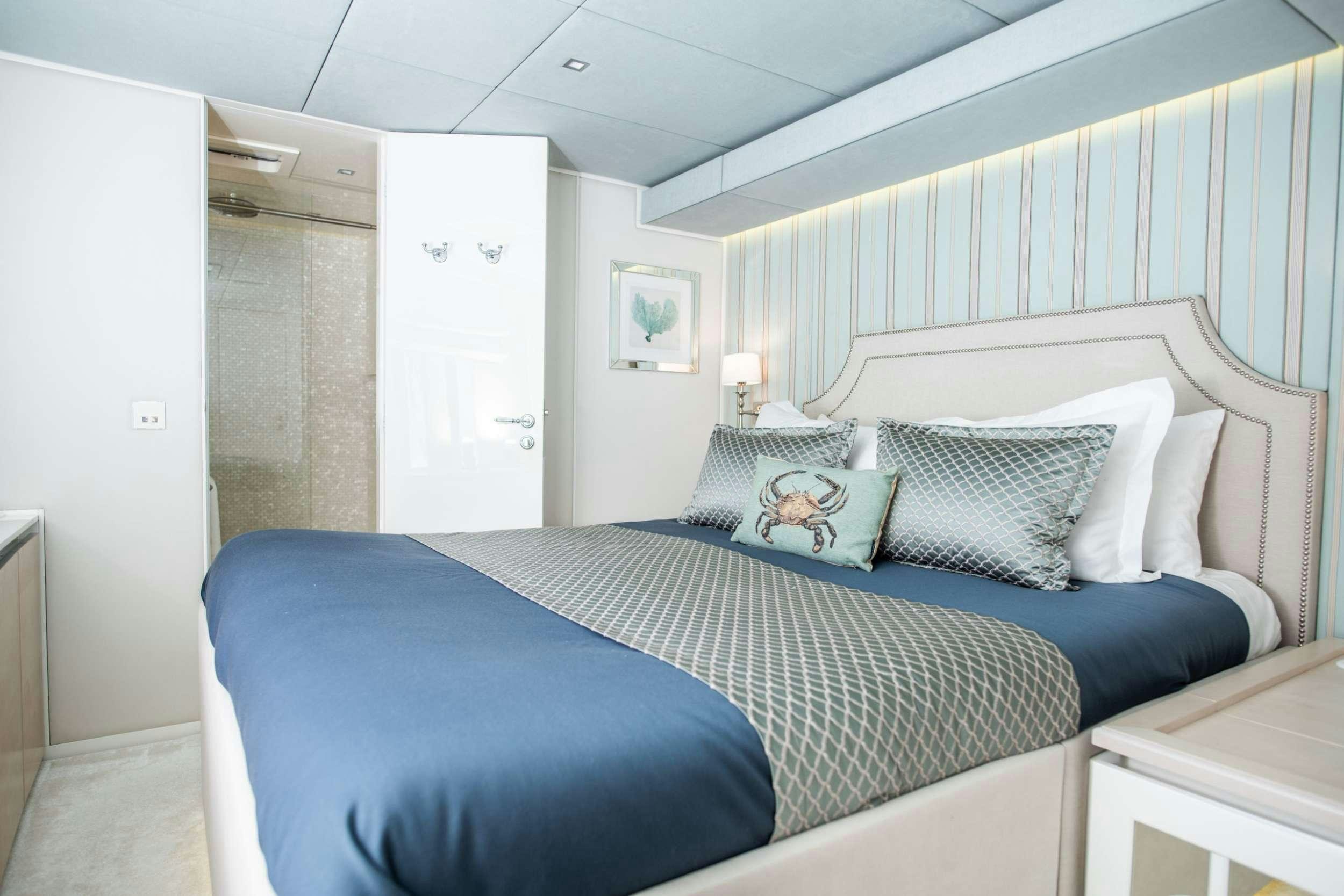 a bedroom with a blue bed aboard BUNDALONG Yacht for Charter