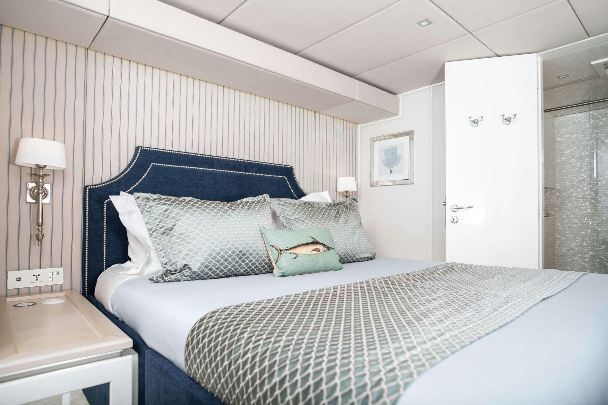 a bedroom with a bed and a lamp aboard BUNDALONG Yacht for Charter