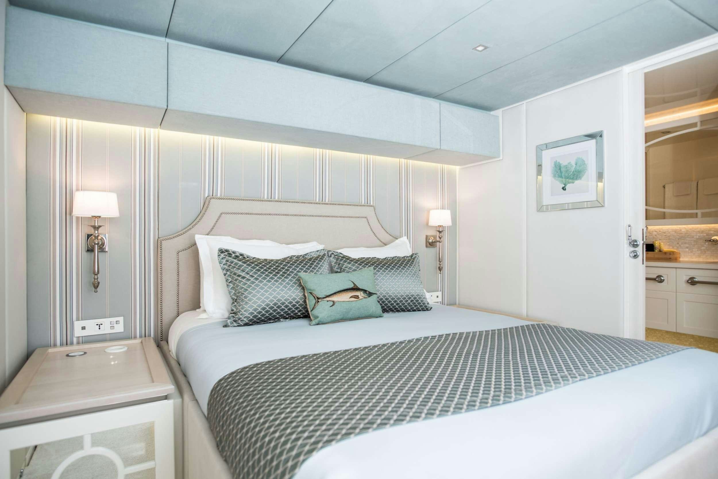 a bed with a white bed spread aboard BUNDALONG Yacht for Charter
