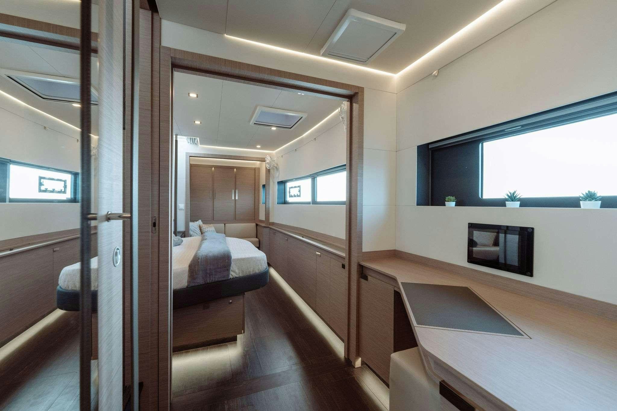 a room with a bed and a television aboard LIQUID SKY Yacht for Charter