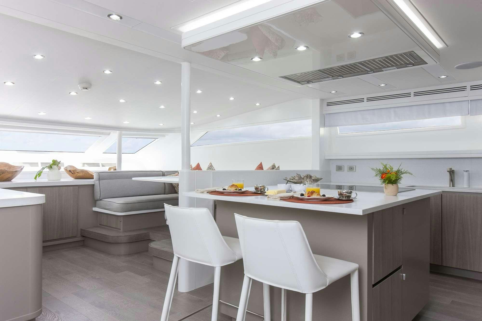 a kitchen with white chairs aboard DADDY Yacht for Charter