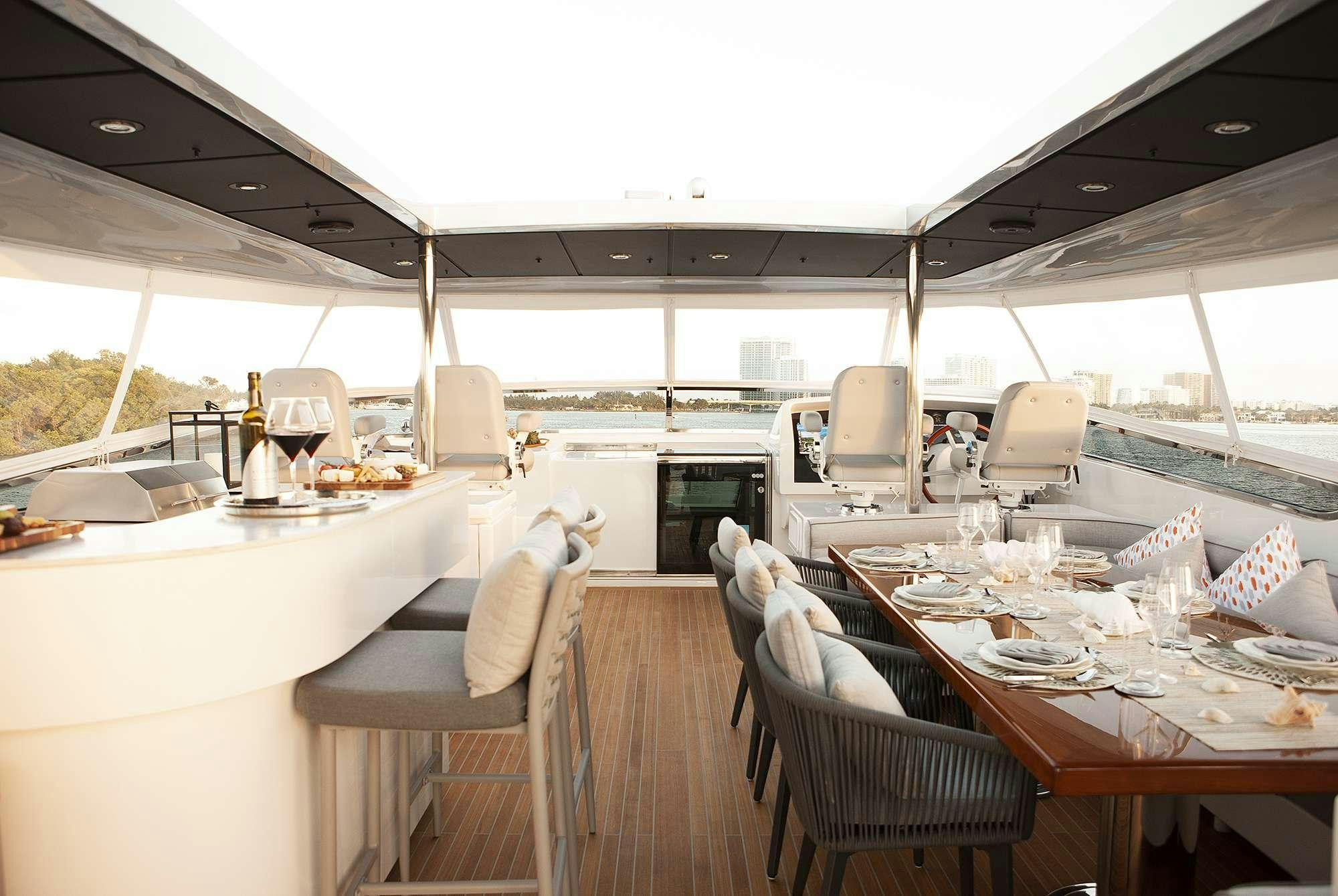 a table with chairs and a couple of laptops on it aboard DADDY Yacht for Charter