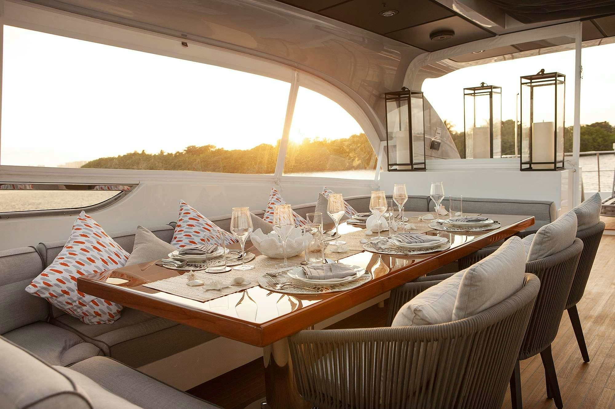 a table with chairs and a large window aboard DADDY Yacht for Charter