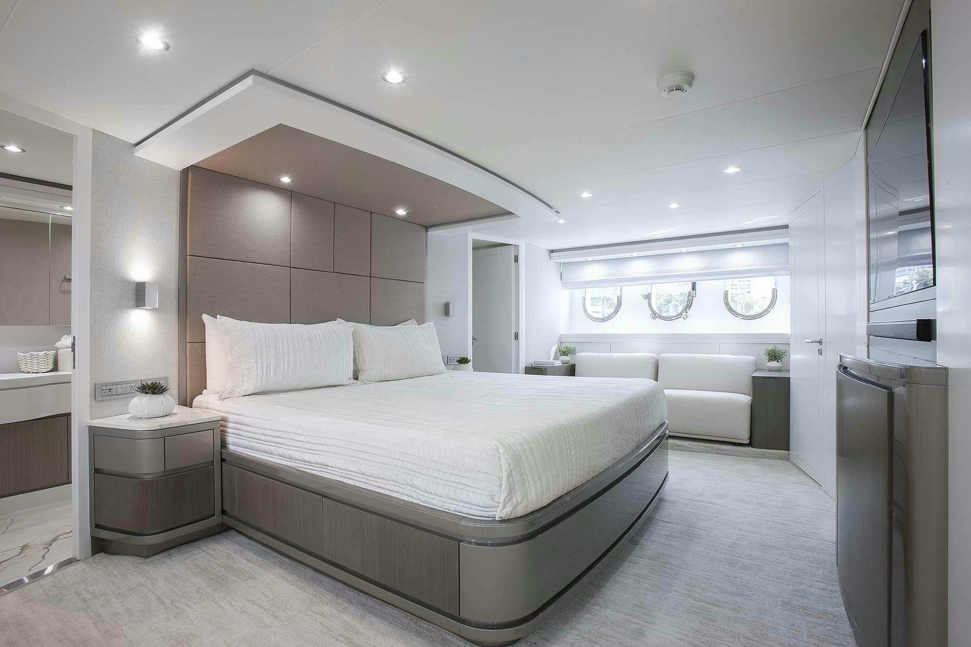 a large white bedroom with a large bed and a large mirror aboard DADDY Yacht for Charter