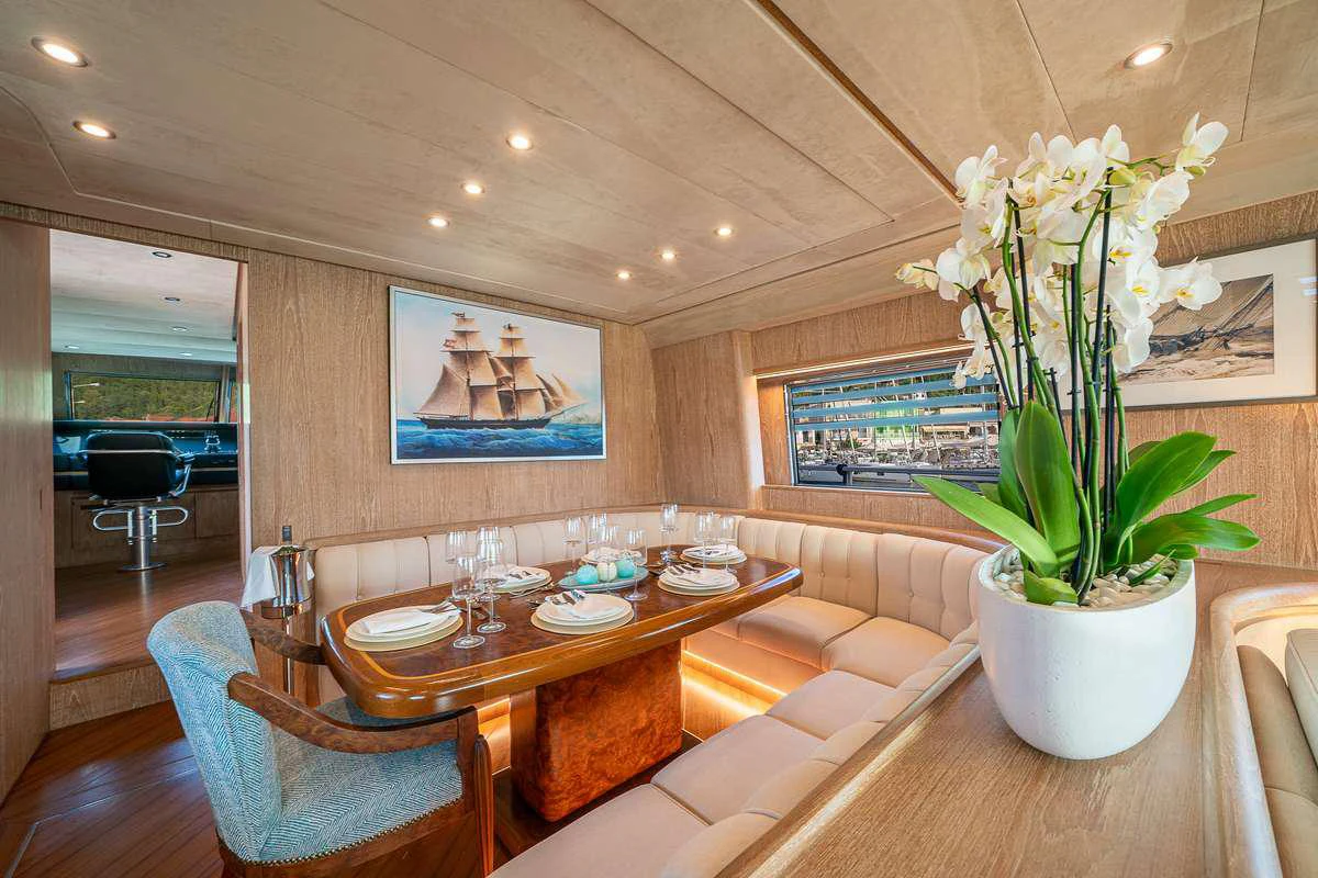a dining room with a plant in a pot on the table aboard OPERA Yacht for Charter