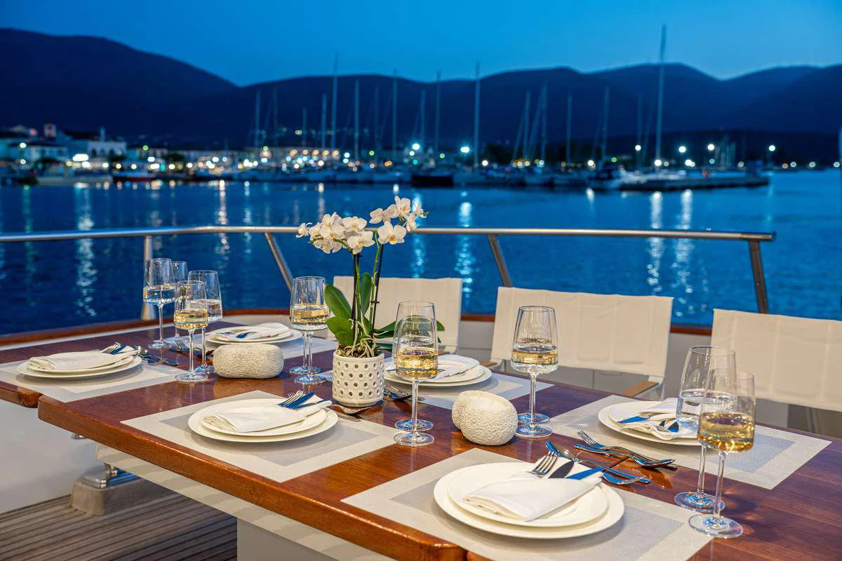 a table set with plates and glasses aboard OPERA Yacht for Charter