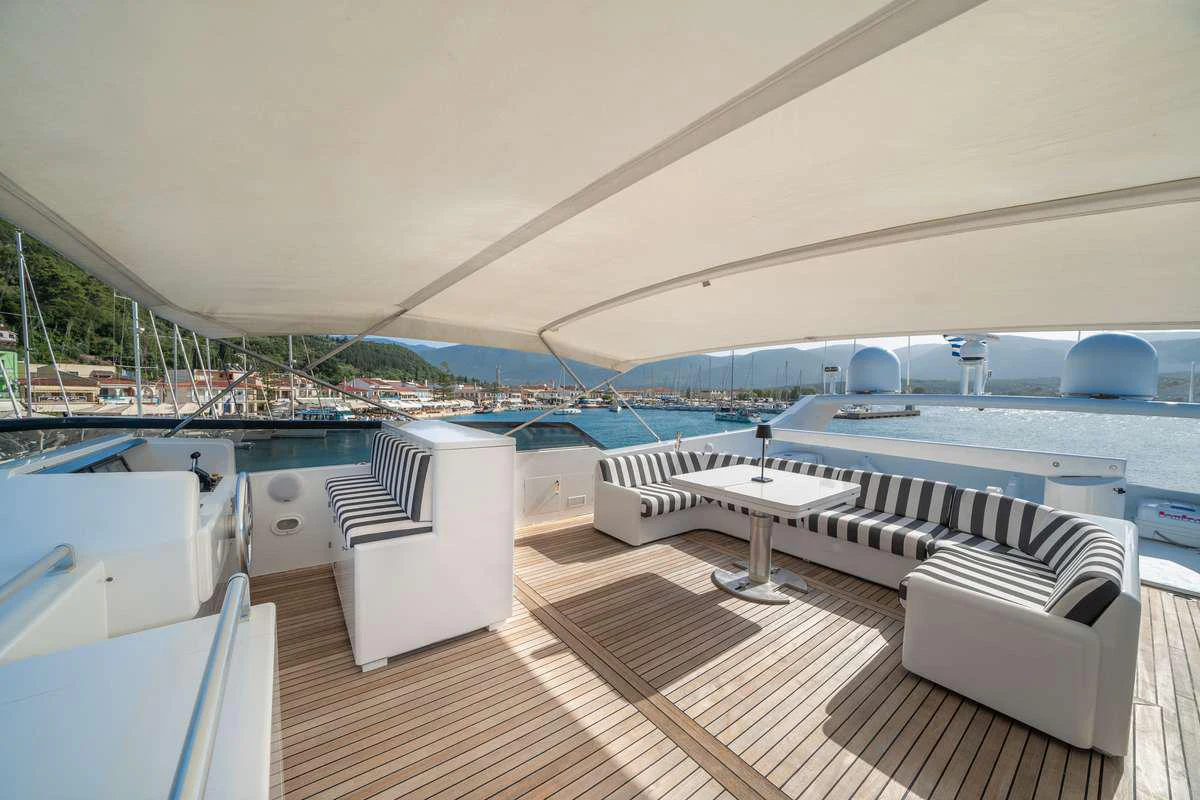 a deck with a view of a body of water and a large boat aboard OPERA Yacht for Charter