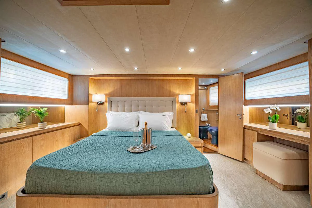 a bed with a blue comforter aboard OPERA Yacht for Charter