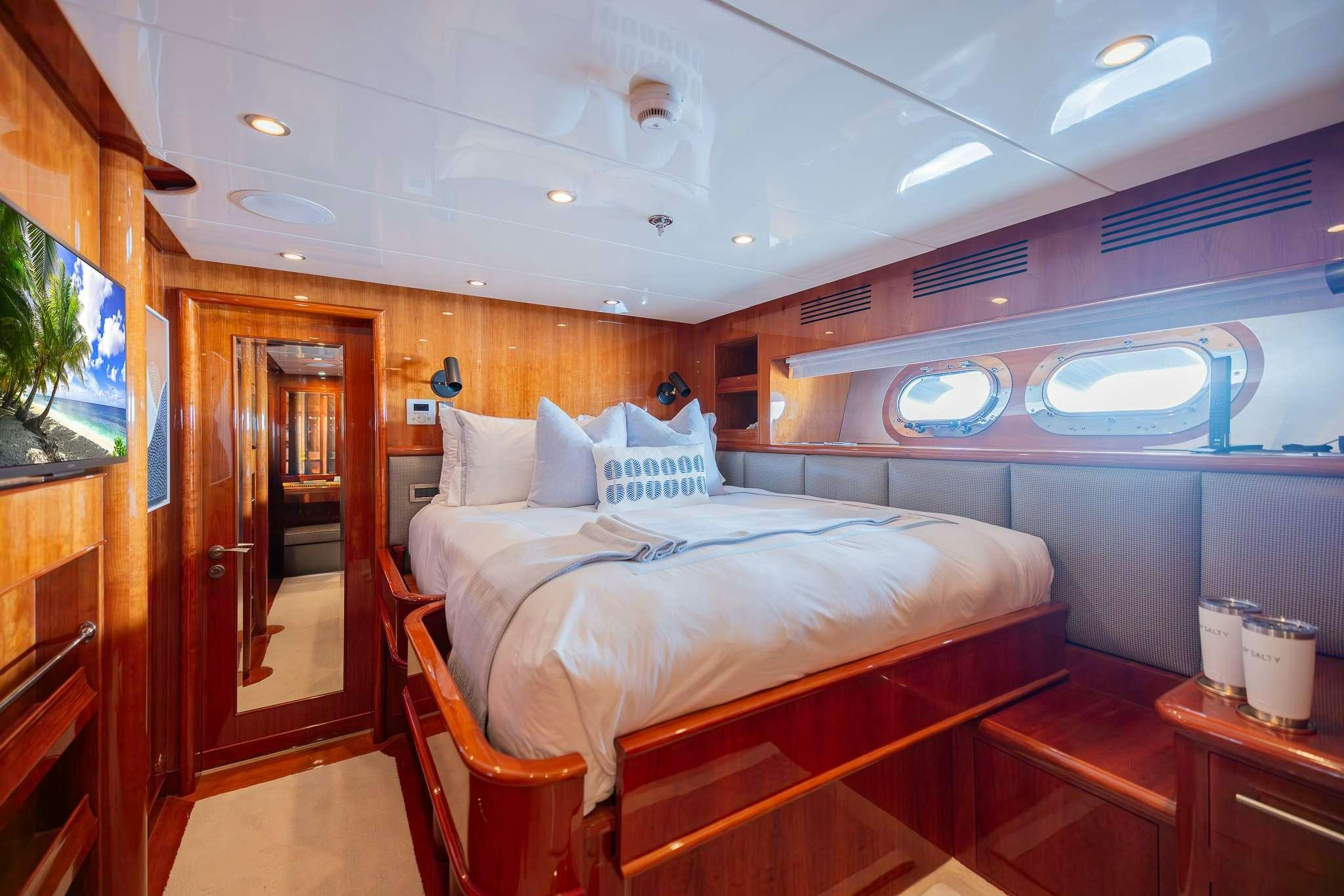 a bedroom with a bed and a mirror aboard STAY SALTY Yacht for Charter