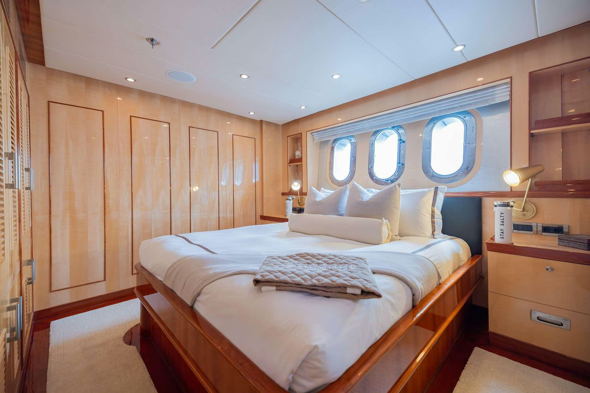 a bedroom with a bed and a window aboard STAY SALTY Yacht for Charter