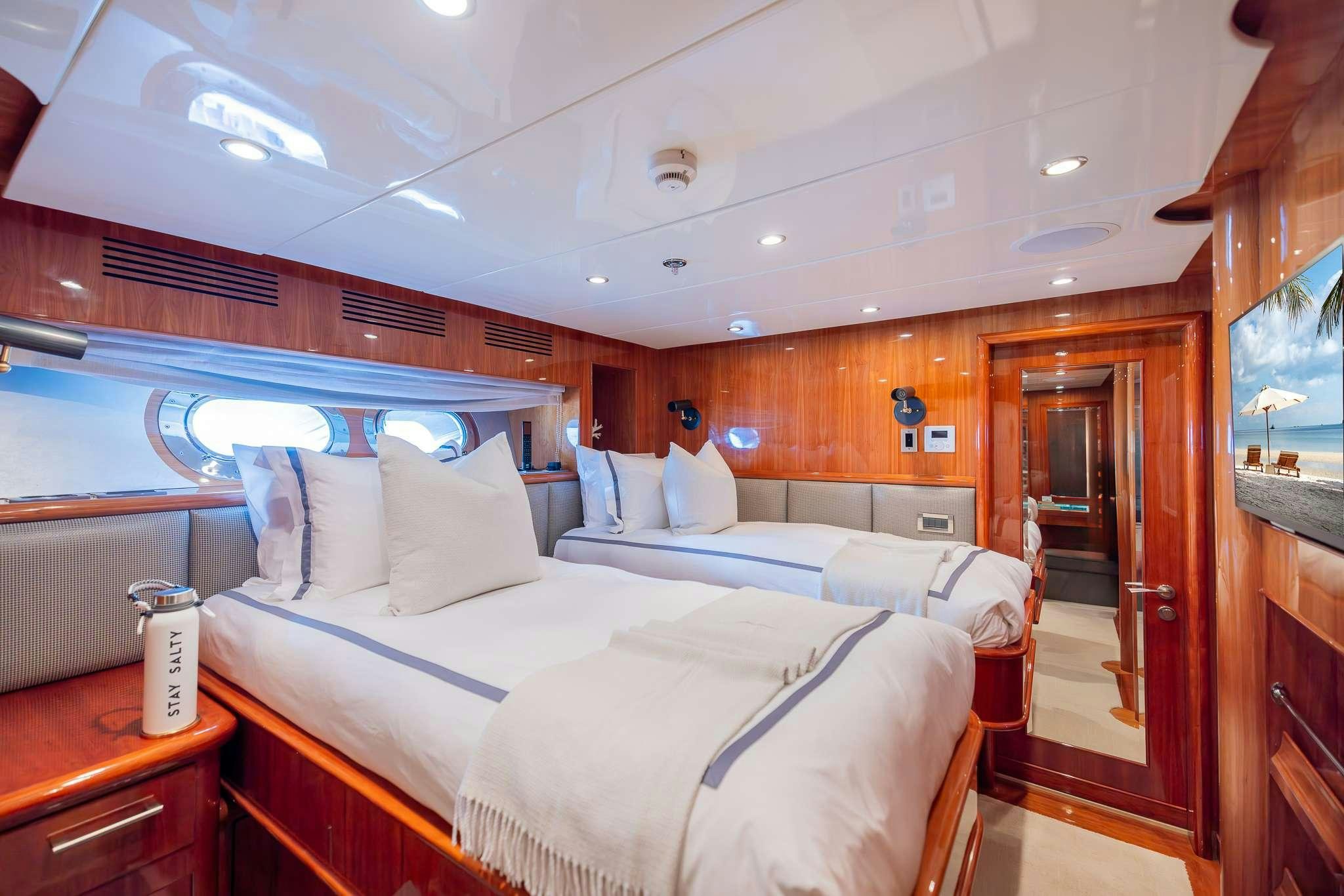 a room with a bed and a television aboard STAY SALTY Yacht for Charter